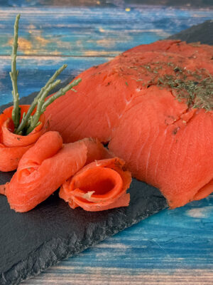 Graved-Sockeye-Lachs aus Wildlachs mit Gewürzen auf Schieferplatte angerichtet.